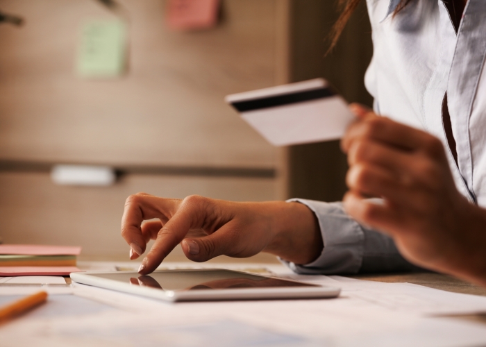 Closeup businesswoman using digital tablet credit card while checking her online bank account